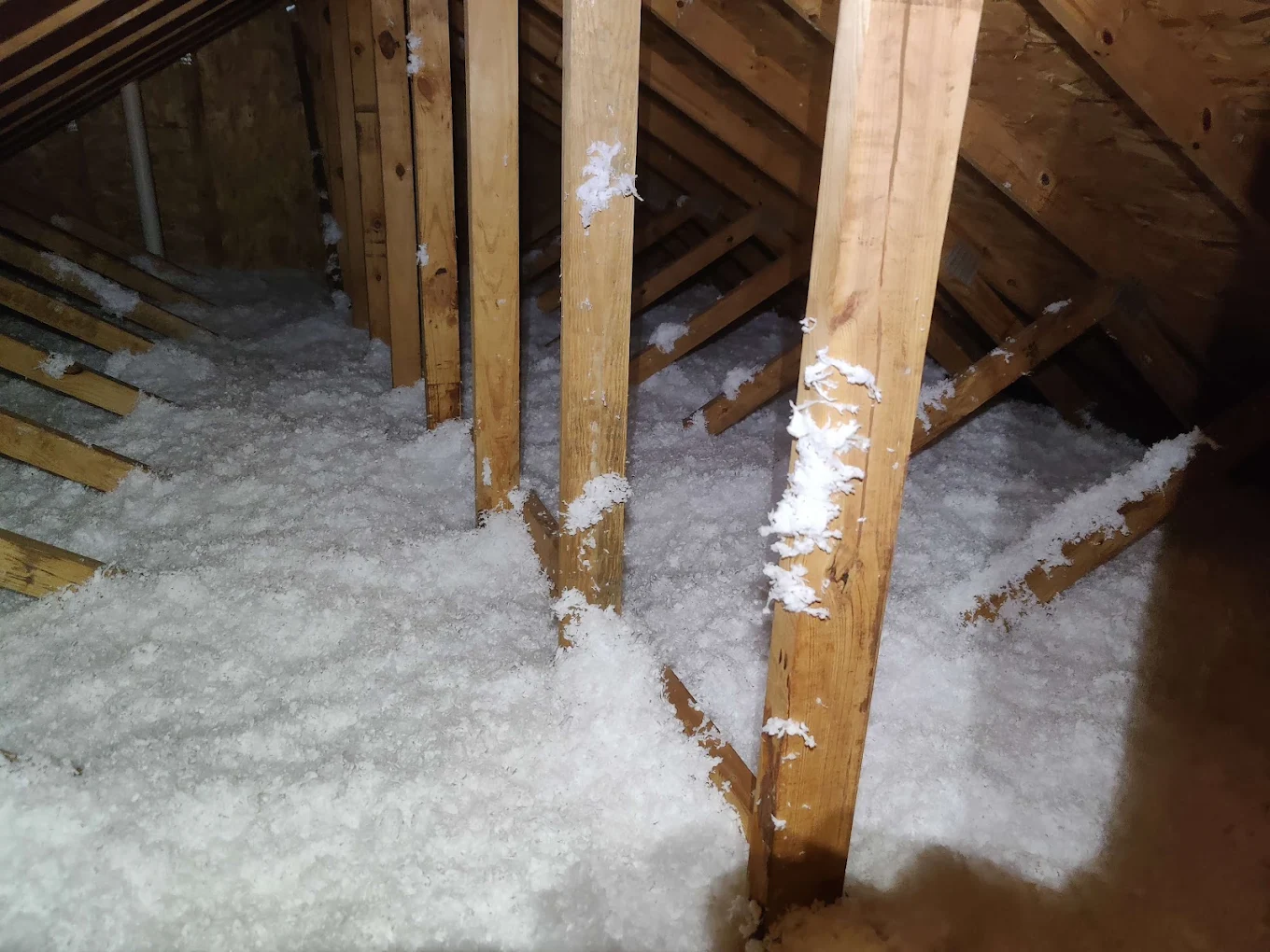 Attic joists buried in an even layer of new blown-in insulation