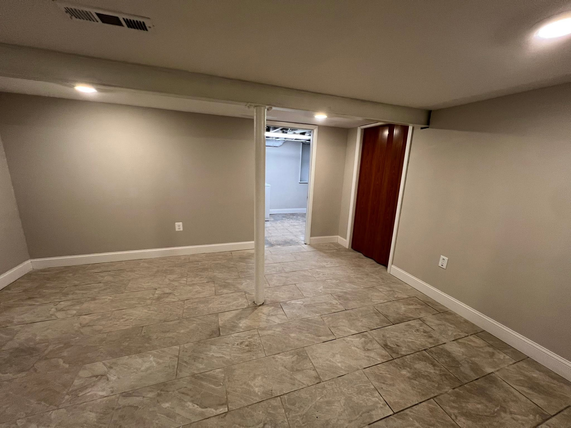 Finished basement family room with large-format tile floor