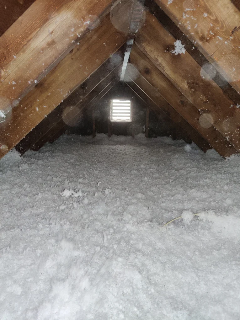 Attic after: an even, deep bed of white blown-in insulation across the entire floor