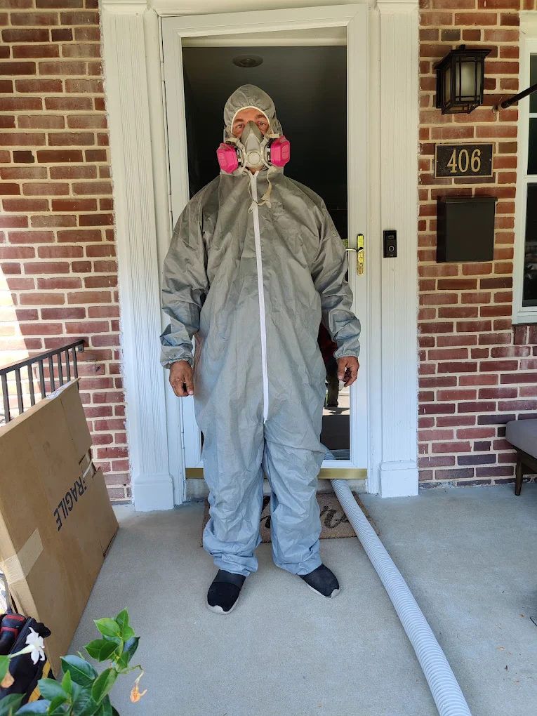 Joe suited up in a protective coverall and respirator before an attic job