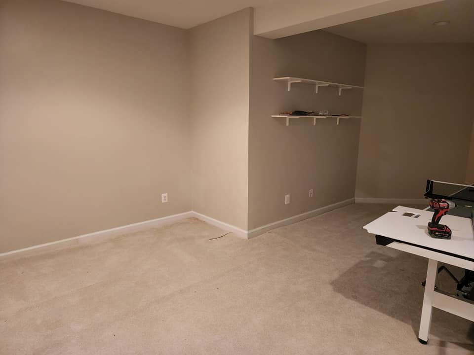 Completed basement with painted walls and floating shelves mounted