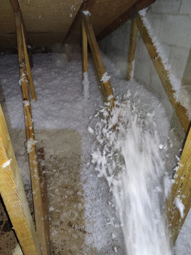 Insulation blowing out of the hose into an attic bay