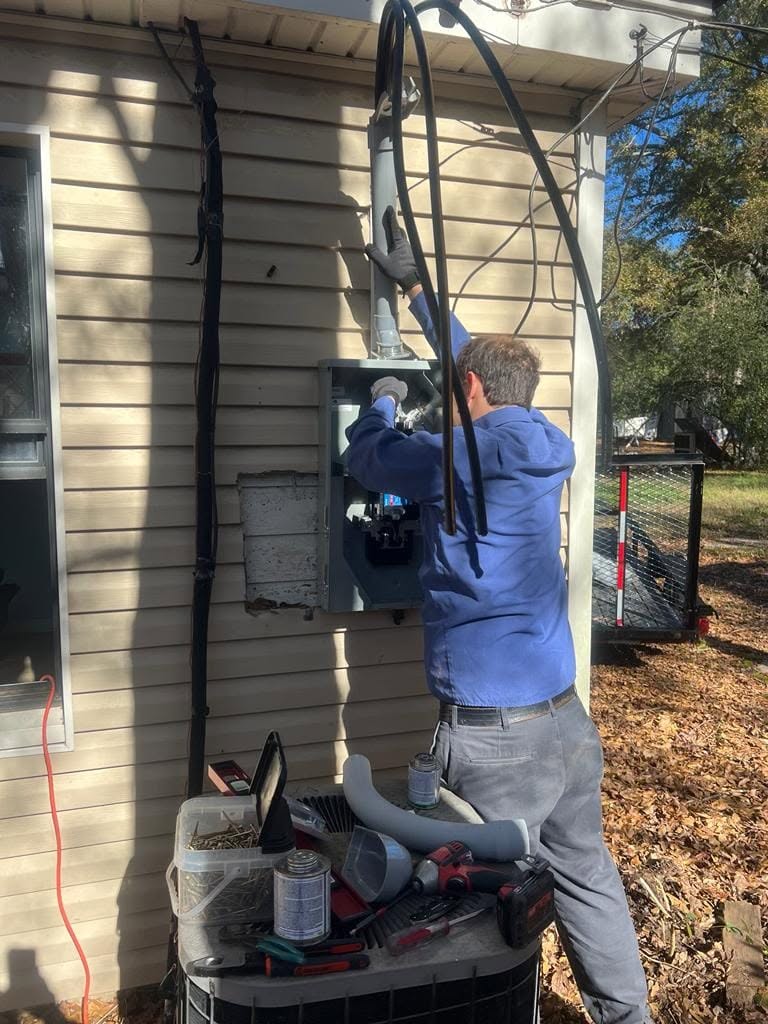 Technician replacing an exterior electrical service panel