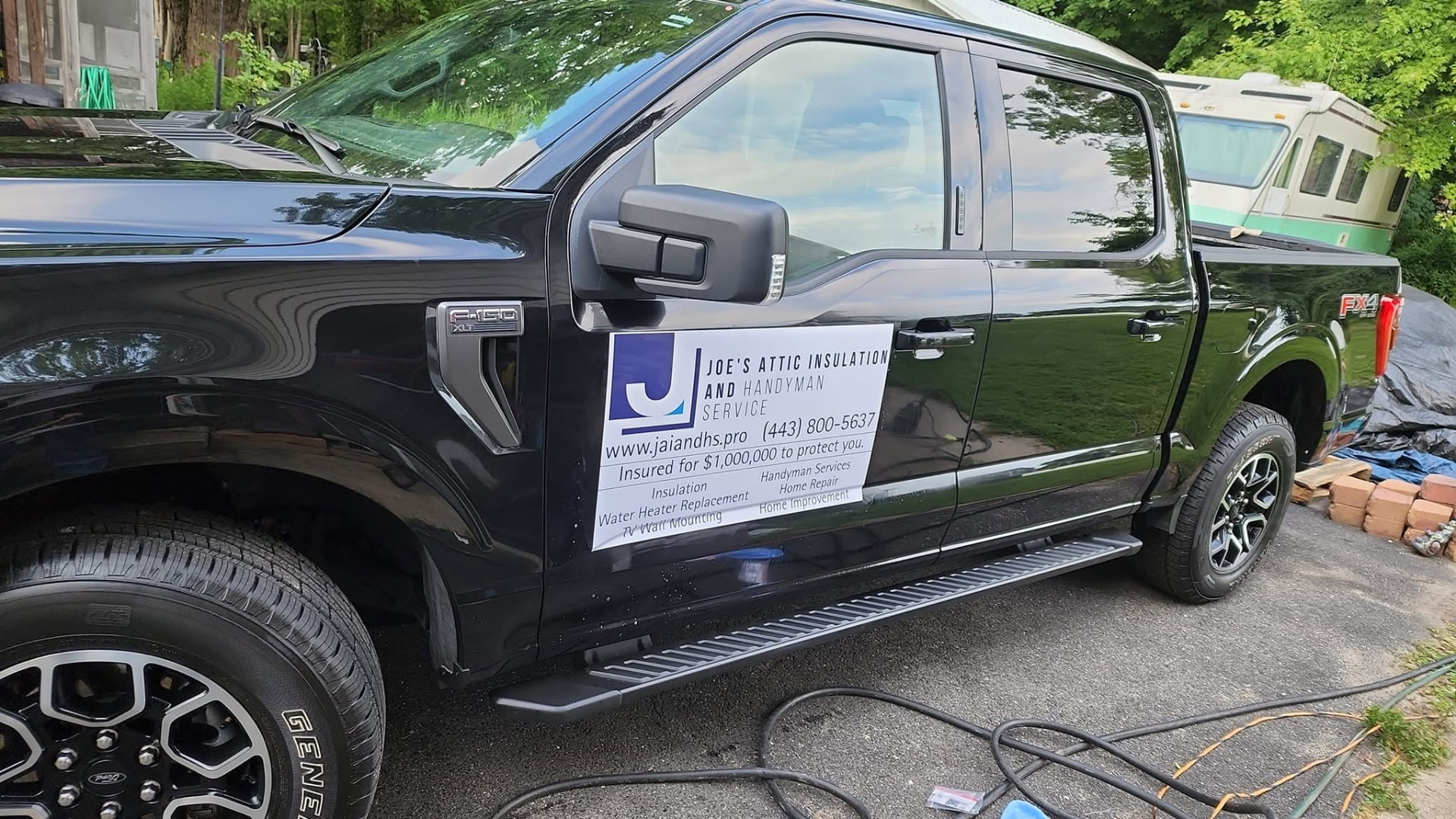 Joe's work truck with services and phone number on the door