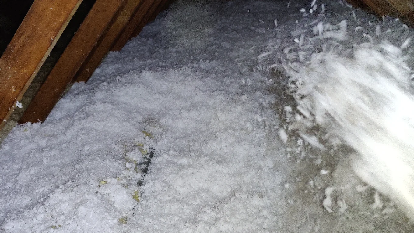 Close-up of blown-in insulation landing on the attic floor