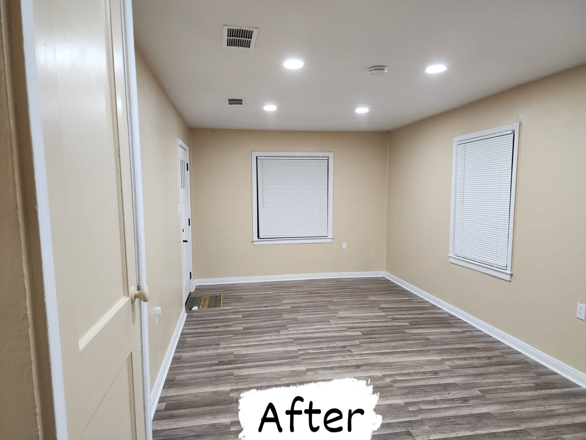 The same living room after: warm paint, plank flooring, white trim and six recessed lights