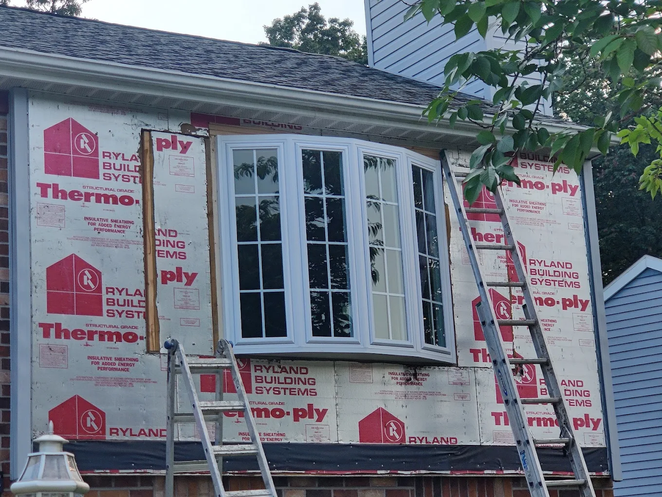 Exterior wall stripped to sheathing around a new bow window