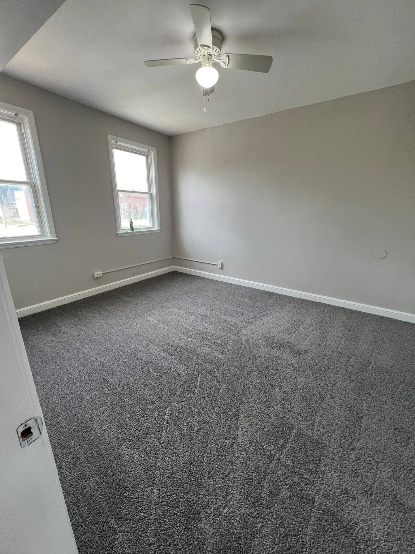 Bedroom with fresh grey paint, new carpet and ceiling fan